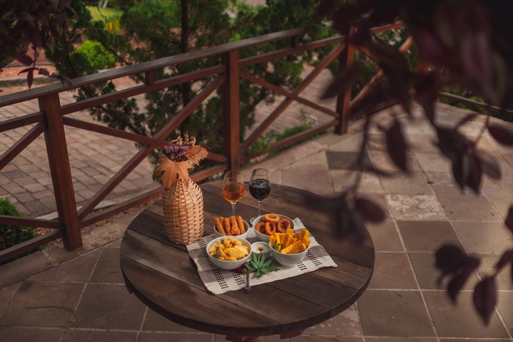 Mesa no deck externo com petiscos e taças de vinho